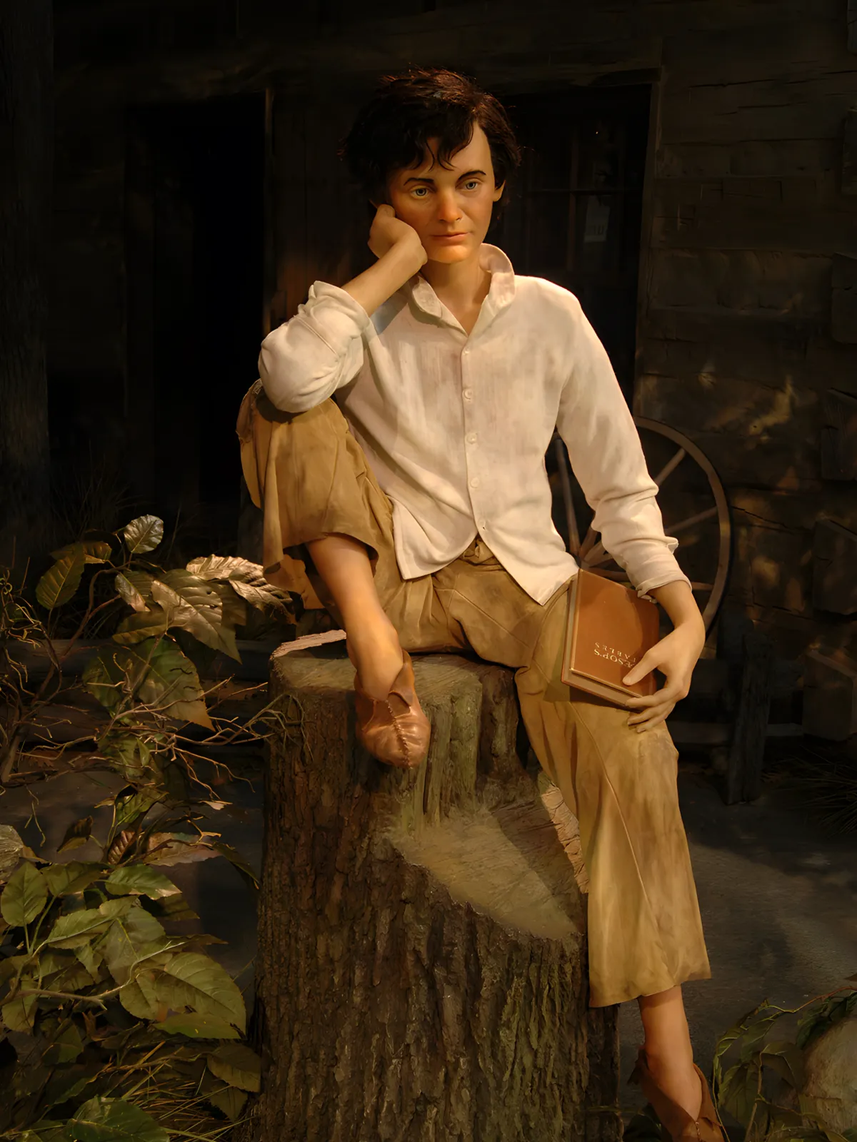 Figure of young boy sitting on stump