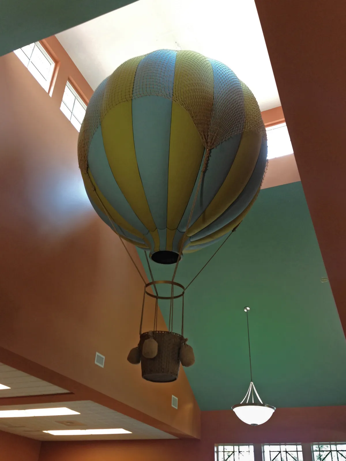 Hot air balloon sculpture floating in tall ceiling