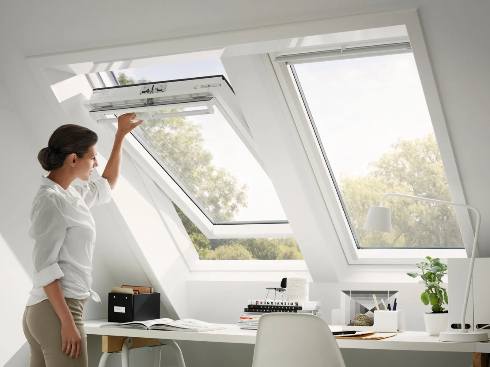 Woman opening skylight in an office